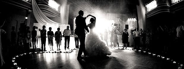 A couple's first dance in a brightly-lit, black and white photo