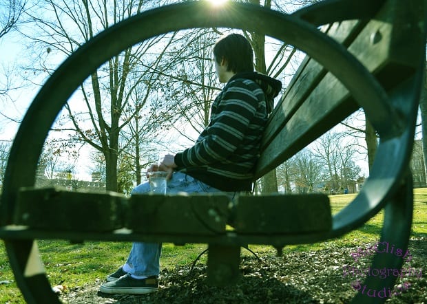 A portrait framed by the inside of a park bench's arm rests