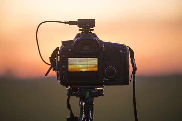 Camera tripod pointed at the sunset