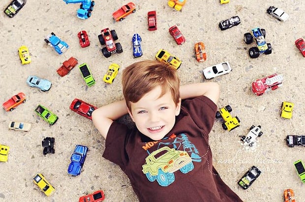 Overhead shot of a boy surrounded by toy cars