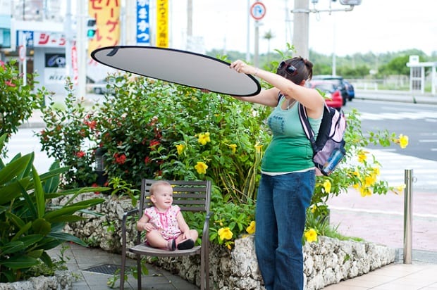 A woman holds a lighting prop over a baby