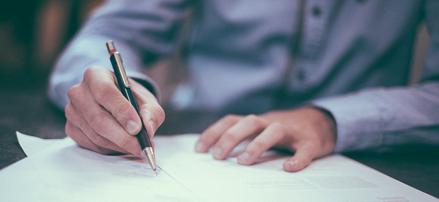 Someone signing a document