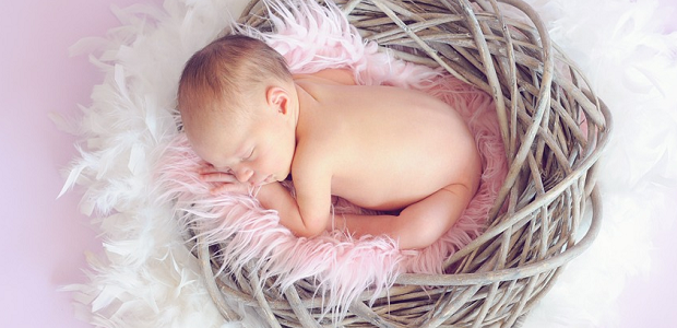 A newborn baby laying in a basket