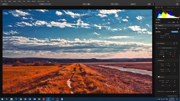 A large orange-toned field with a bright blue sky on the horizon