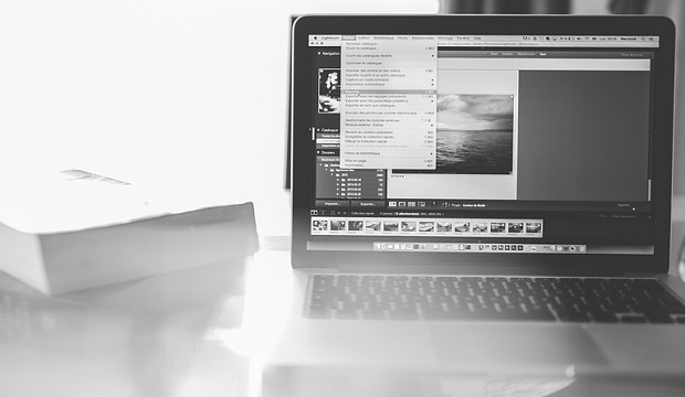 A black and white image of a laptop, with photo editing software open and in use