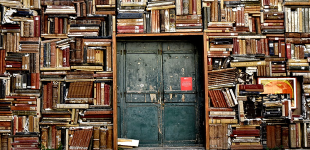 Large metal doors completely surrounded by shelves full of books