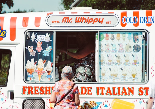 Close shot of italian ice truck with single patron standing in front