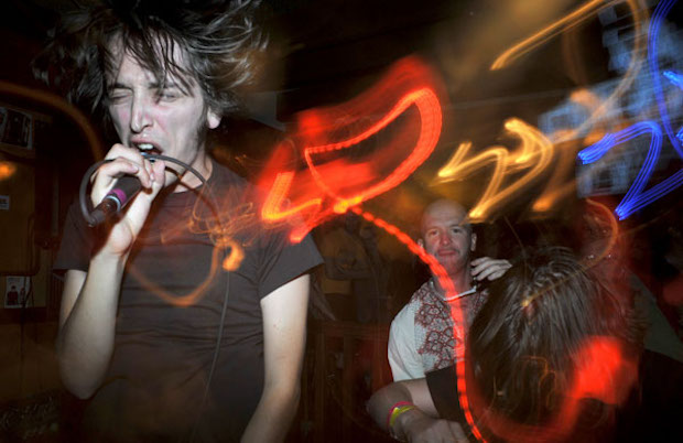 Vocalist singing into microphone with streaks of light surrounding him 