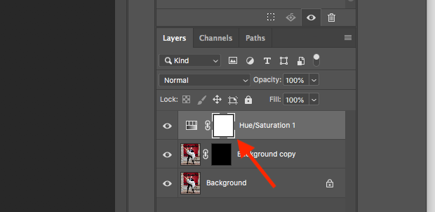 Flecha roja apuntando a la máscara blanca en una capa de ajuste de Tono/Saturación en el Panel Capas de Photoshop