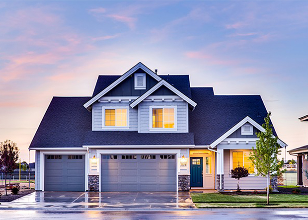 Well-lit home exterior with pink and blue sky background