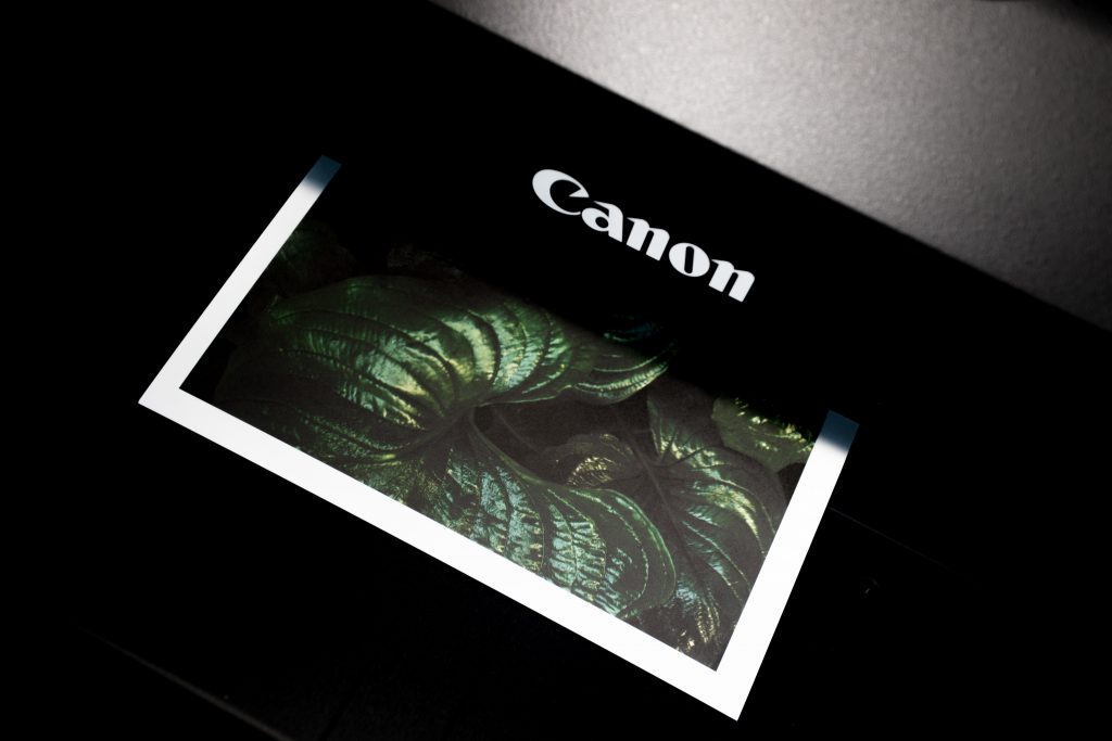 A green-colored print ejecting from a Canon printer 