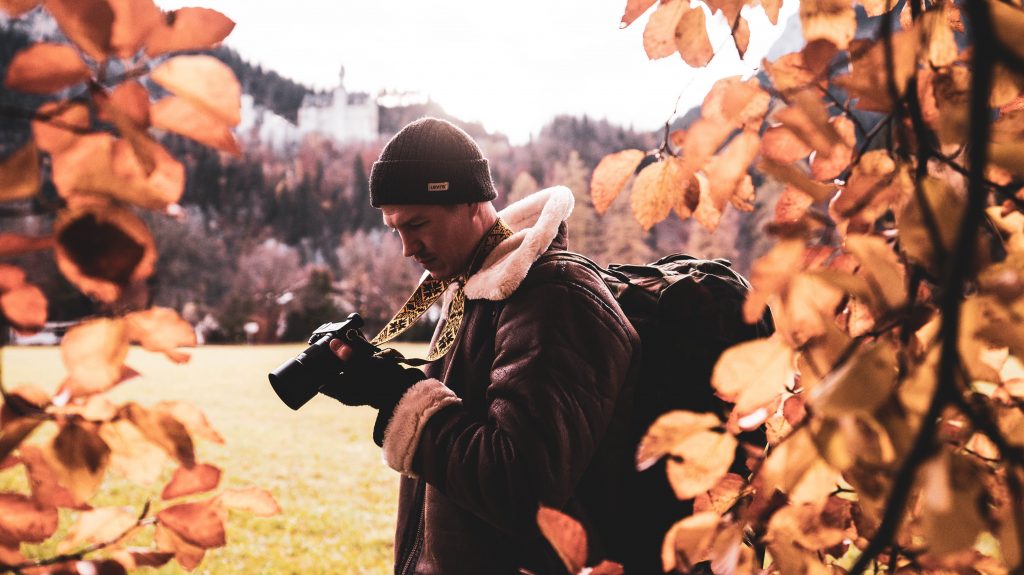 A photographer holding a camera while looking at the camera's display