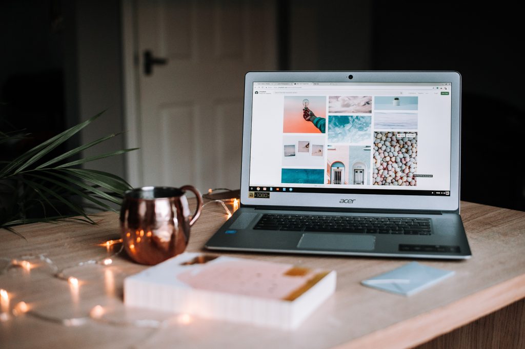 Aesthetic photo of an open laptop near a mug and book