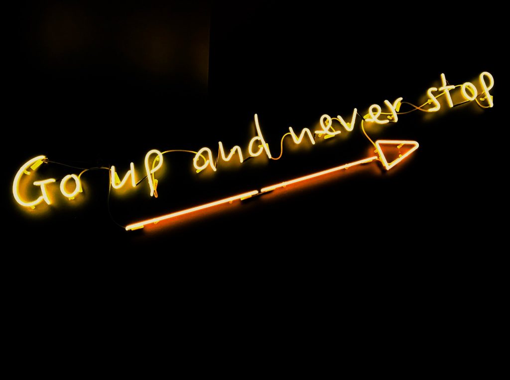 An LED sign board stating go up and never give up